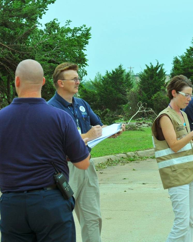 Damage assessment team with clipboards on a storm-hit street
