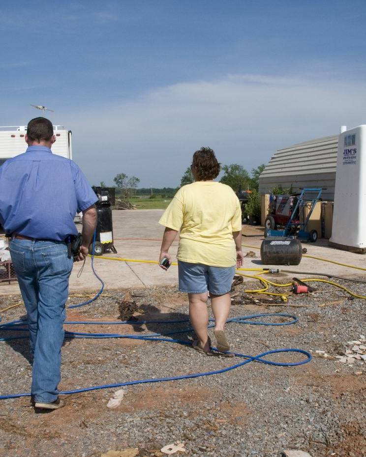 Homeowner and inspector walking a tornado-damaged property