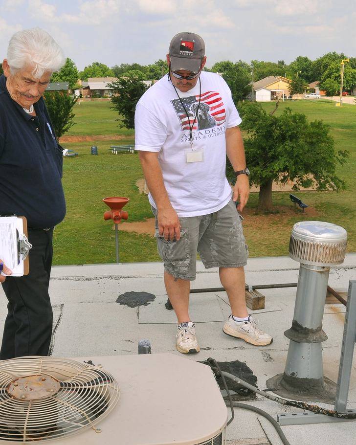 Inspectors documenting damage on a roof