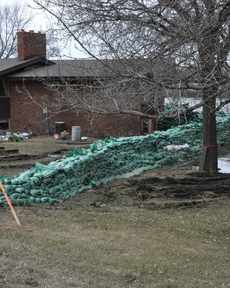 Sandbag wall protecting a home from rising floodwater