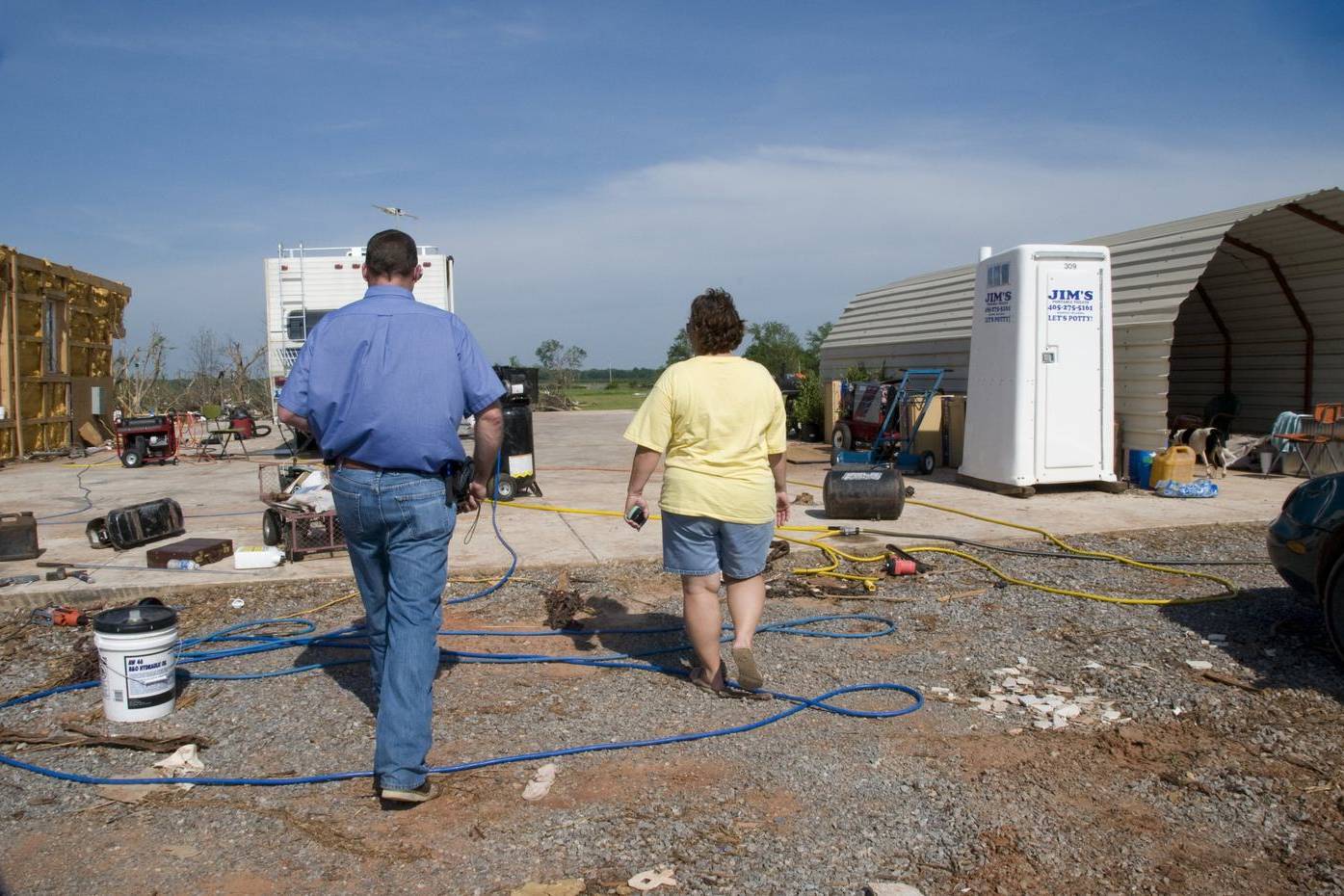 Homeowner and inspector walking a tornado-damaged property